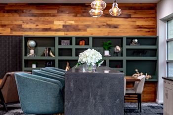 a dining room with green chairs and a table with white flowers at 310 at Nulu Apartments-Student, Kentucky